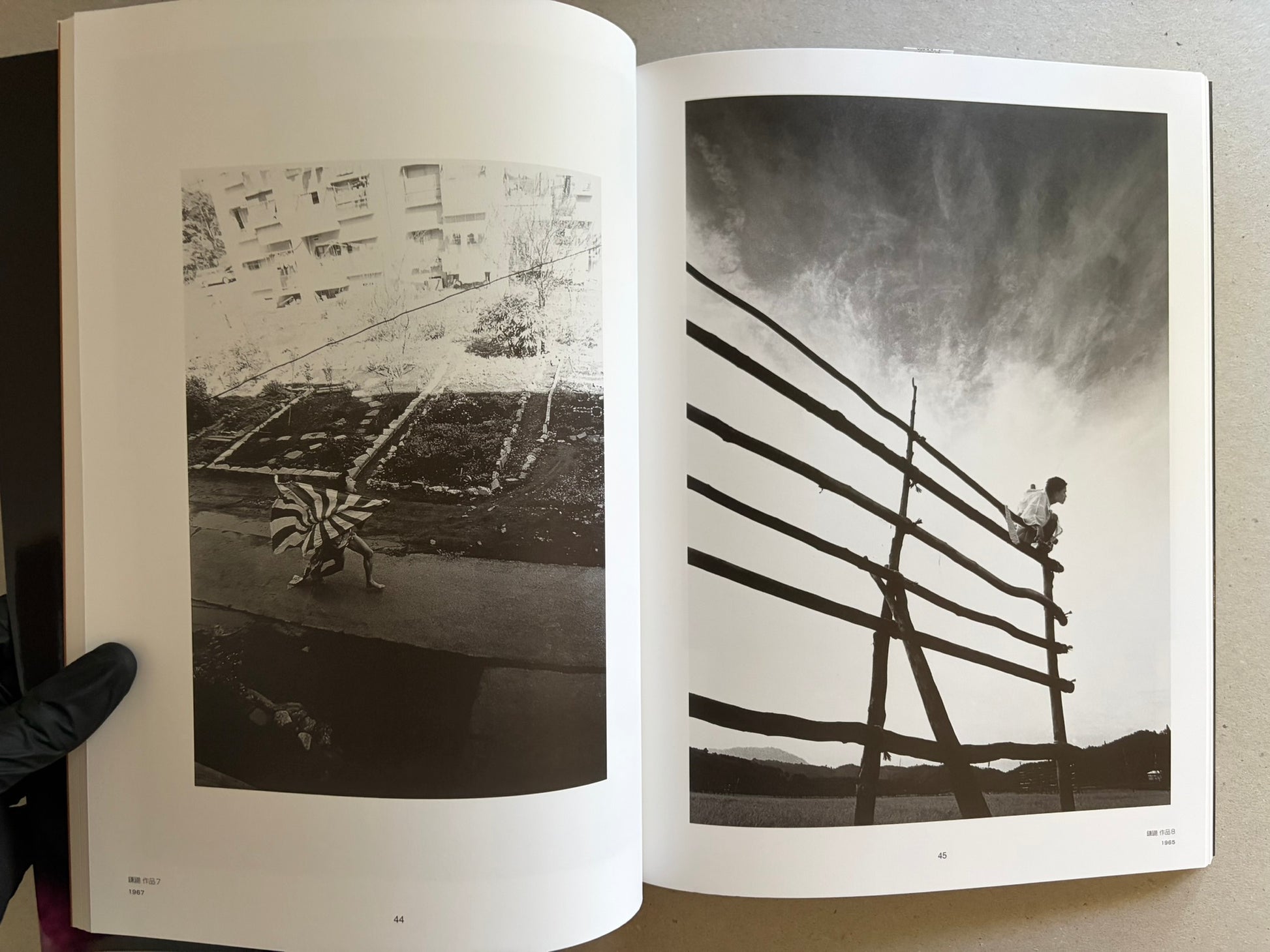 Two-page spread with black-and-white outdoor photographs, including a figure carrying a striped cloth and another climbing a wooden structure.