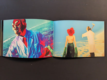 Inside spread from “AKARUIMIRAI” with repeated images of a topless woman with a red flower head and a man in a white coat on a bright blue and yellow beach.