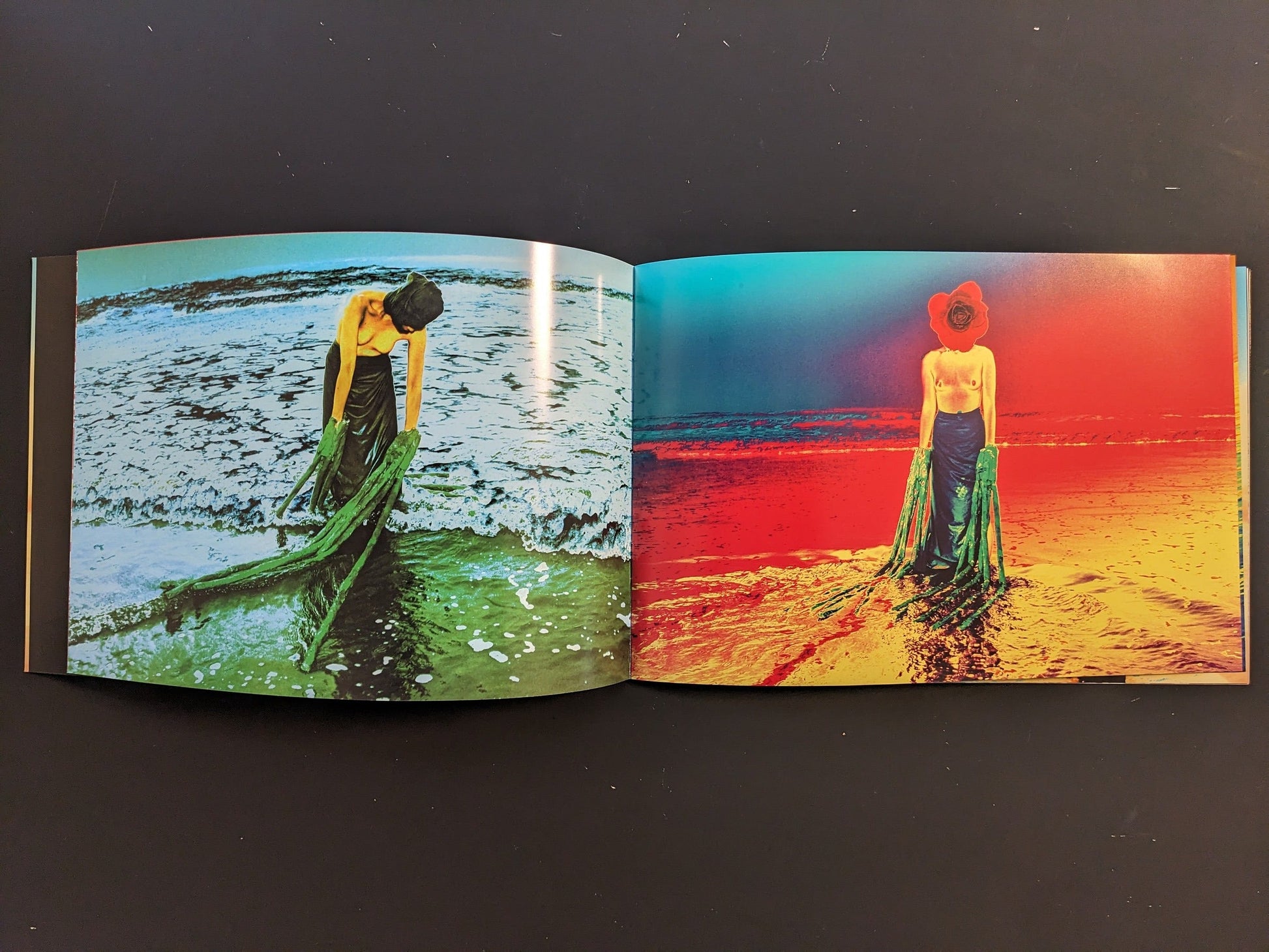 Inside spread from “AKARUIMIRAI” showing two versions of the same woman standing in the surf, one in greenish tones and one in intense red and blue.