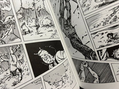 Close view of an open Akutezoïde comic spread with dense black-and-white linework, figures in action, and multiple panels across both pages.