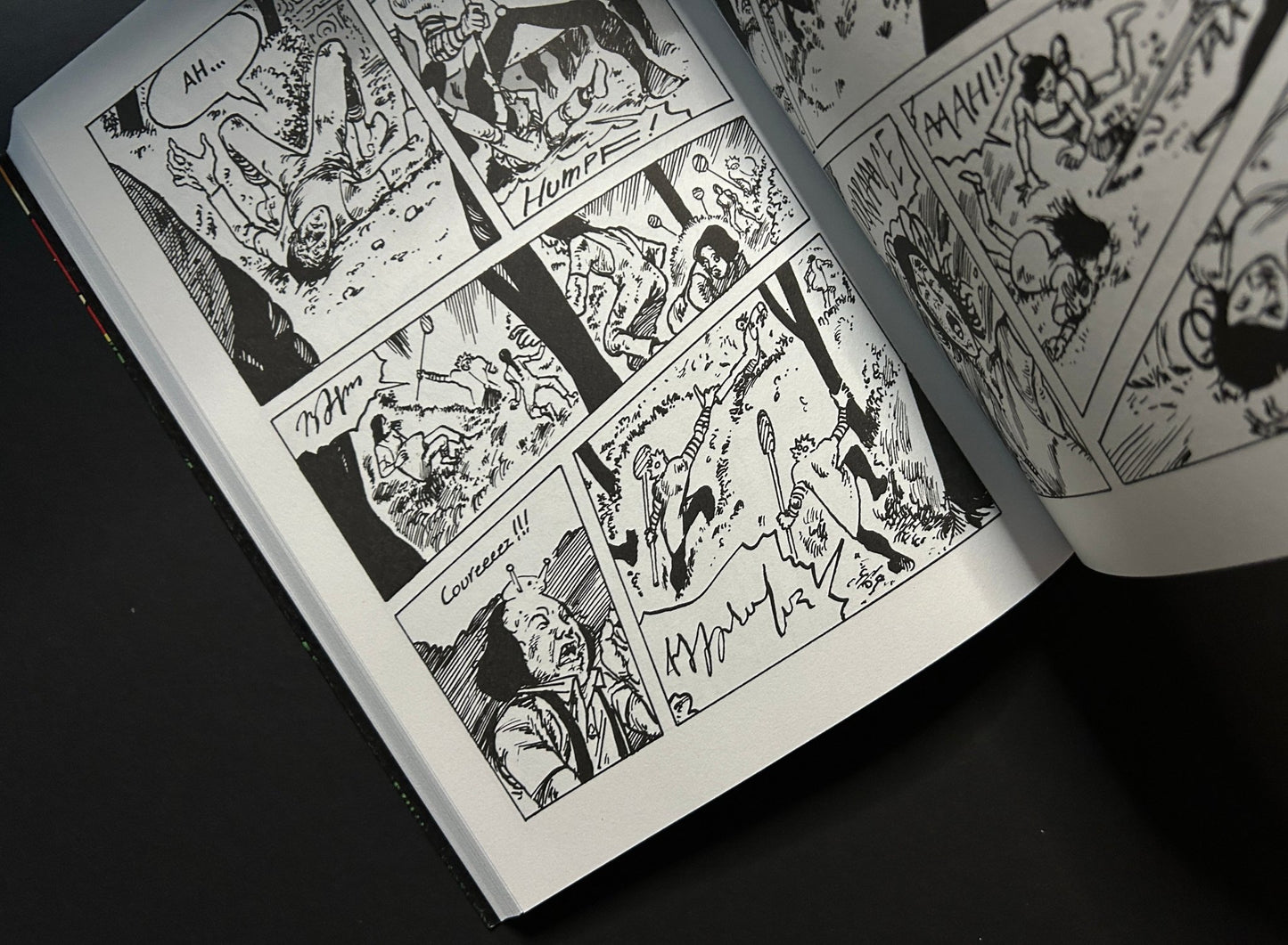 Open black-and-white comic spread showing several panels with figures in motion and handwritten sound effects.