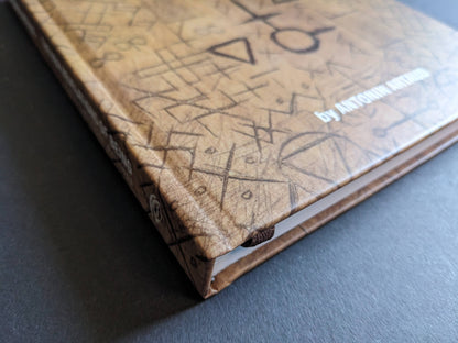Close-up of the book spine with embossed title and decorative ritual-like patterns.