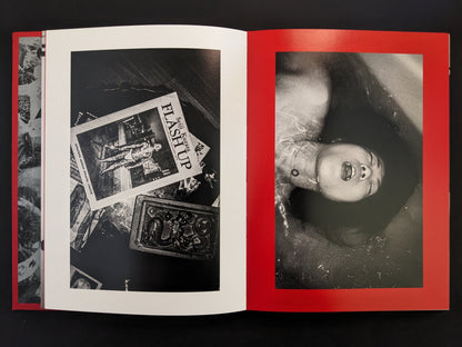 Still life with cards and a woman submerged in a bathtub.