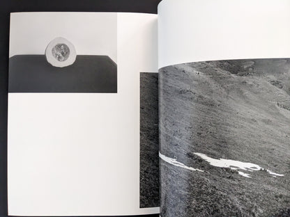 Page from Ash (New Edition) by Muge, close-up black-and-white photograph of textured rock surfaces.