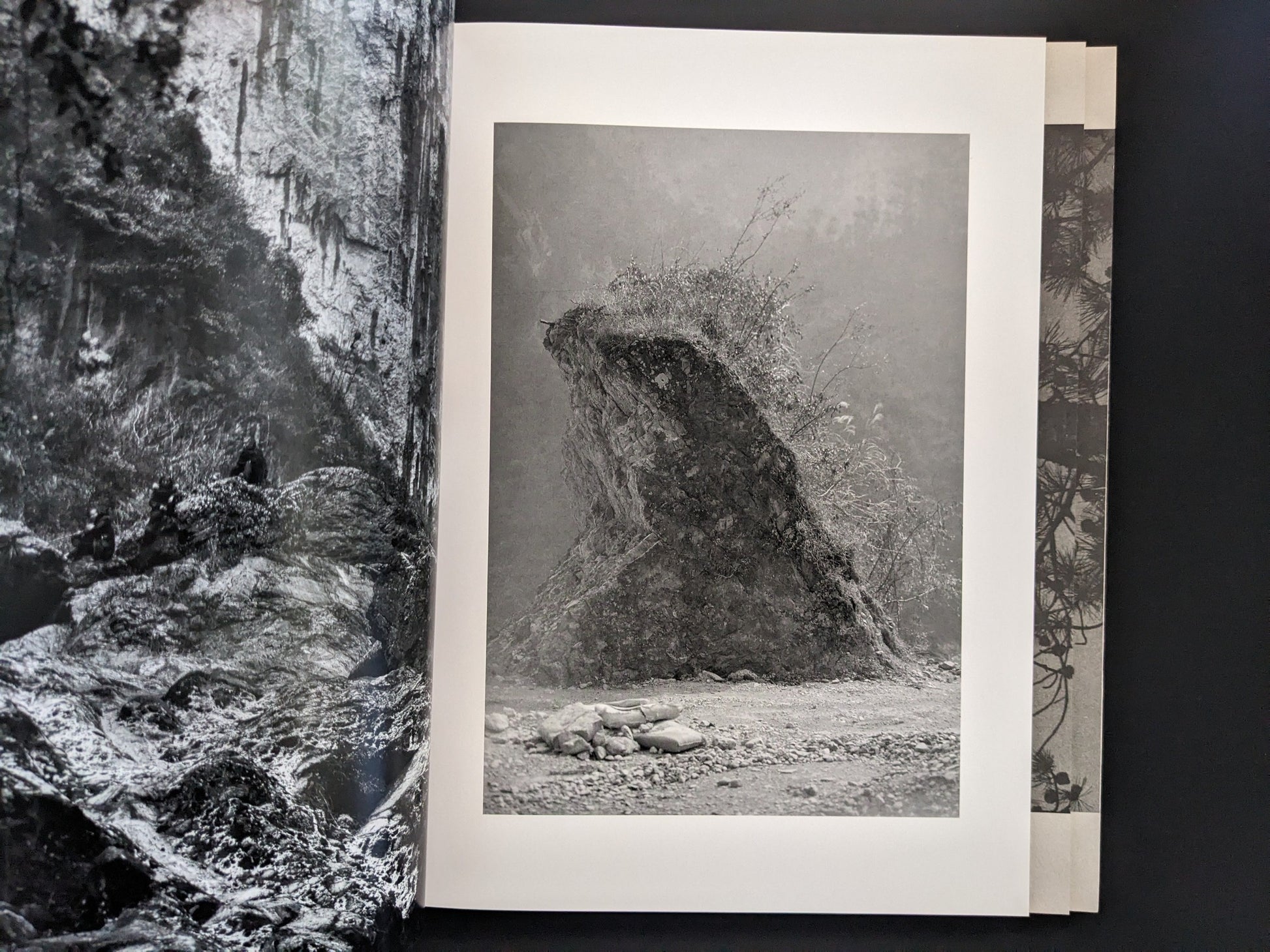 Open spread from ASH (New Edition) by Muge, with a landscape photograph on the right page.