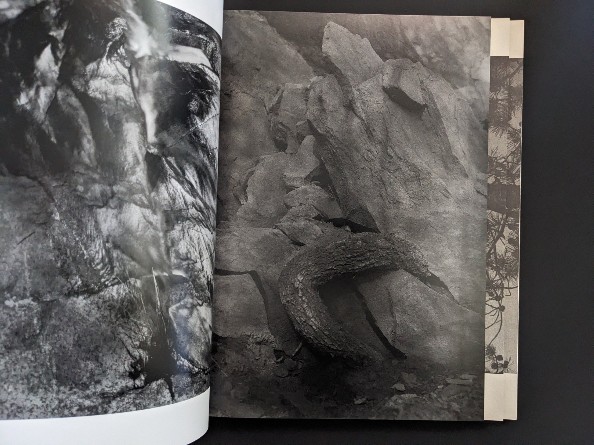Open spread from ASH (New Edition) by Muge, showing a close-up black-and-white rock composition.