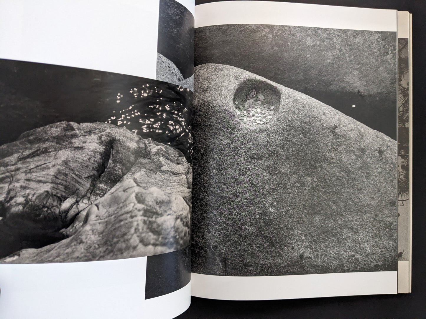 Open spread from ASH (New Edition) by Muge, showing rock formations in black and white.