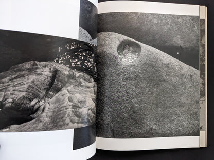 Open spread from ASH (New Edition) by Muge, showing rock formations in black and white.