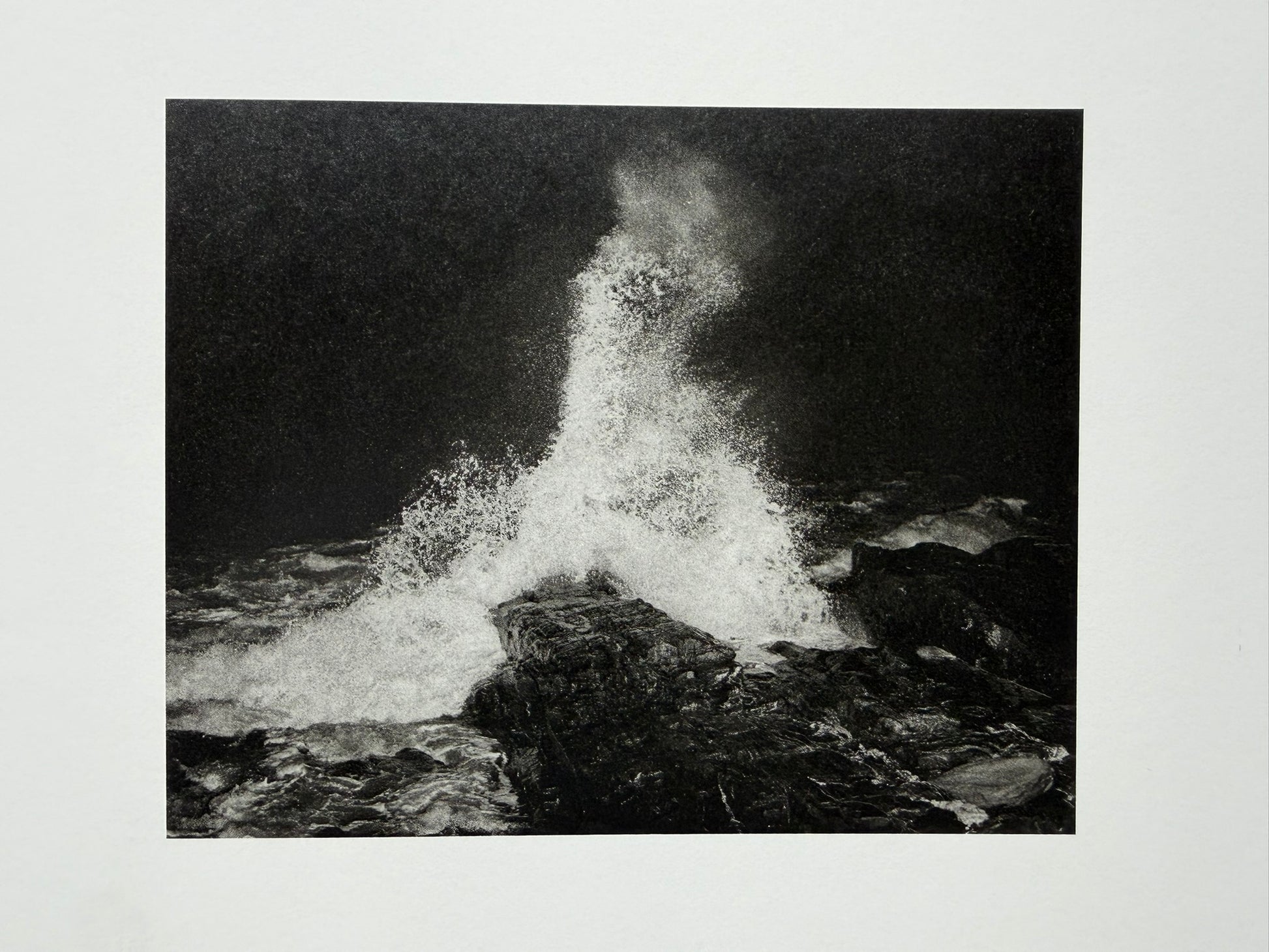 At Night Gardens Grow by Pia-Paulina Guilmoth, black-and-white photograph of water splashing over rocks on a printed page