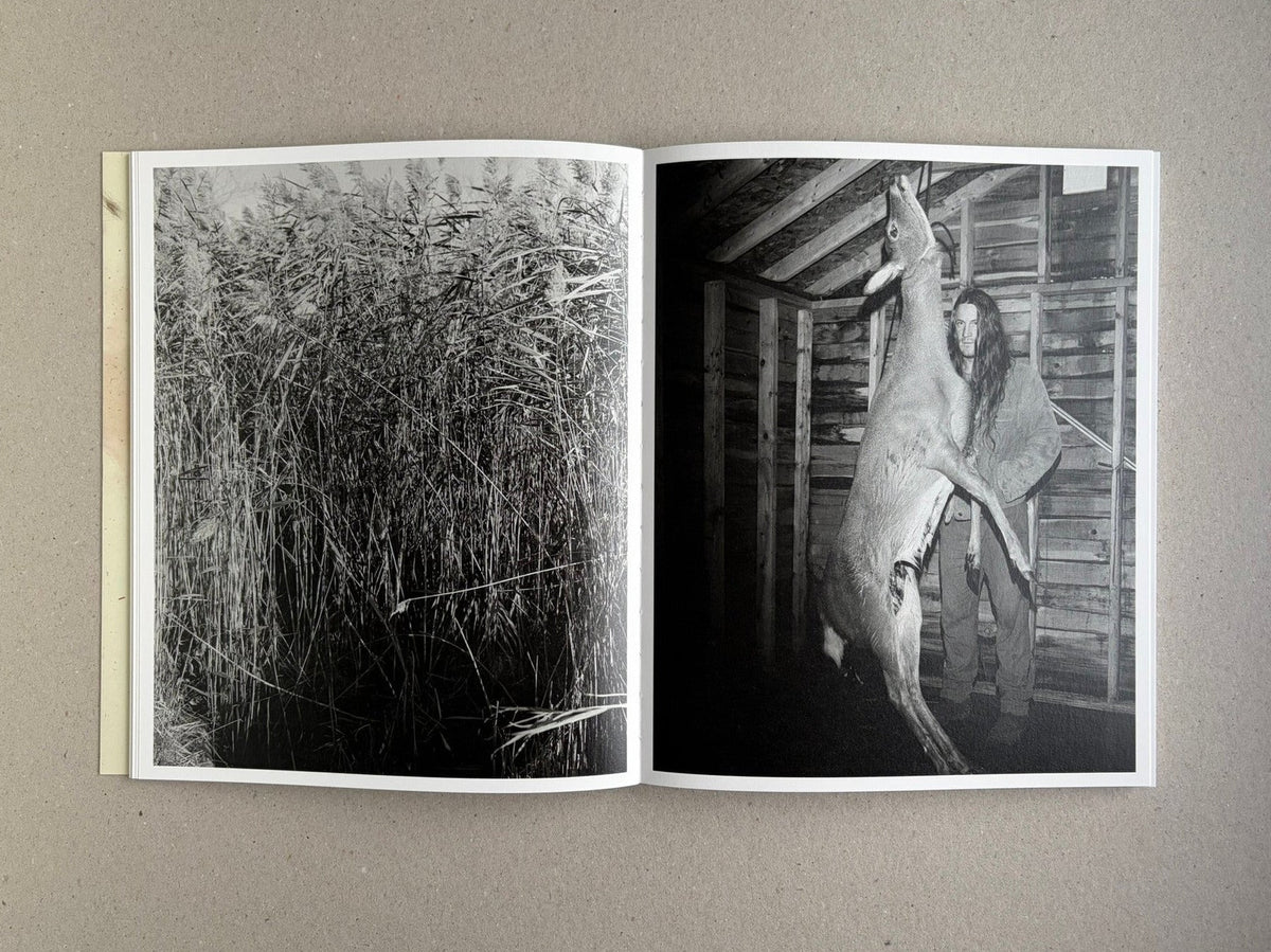 At Night Gardens Grow open to a black-and-white spread with reeds on the left and a person holding a deer on the right