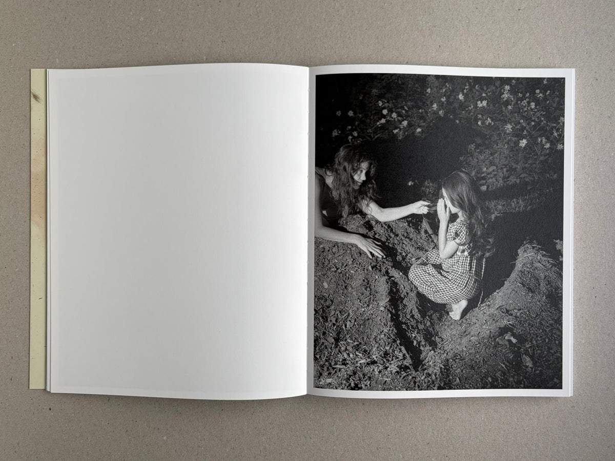 At Night Gardens Grow open to a black-and-white photograph of two people in a garden at night