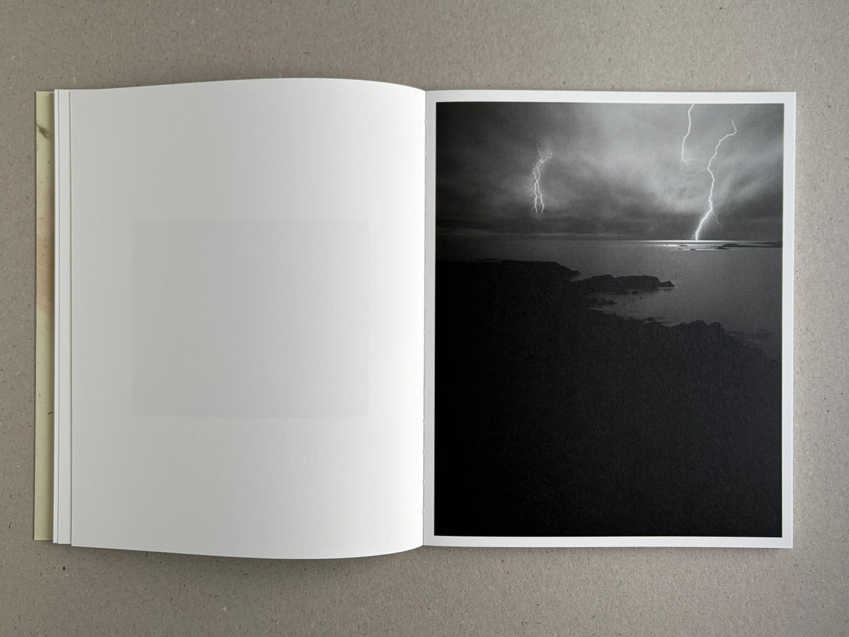 At Night Gardens Grow open to a black-and-white landscape with lightning over water