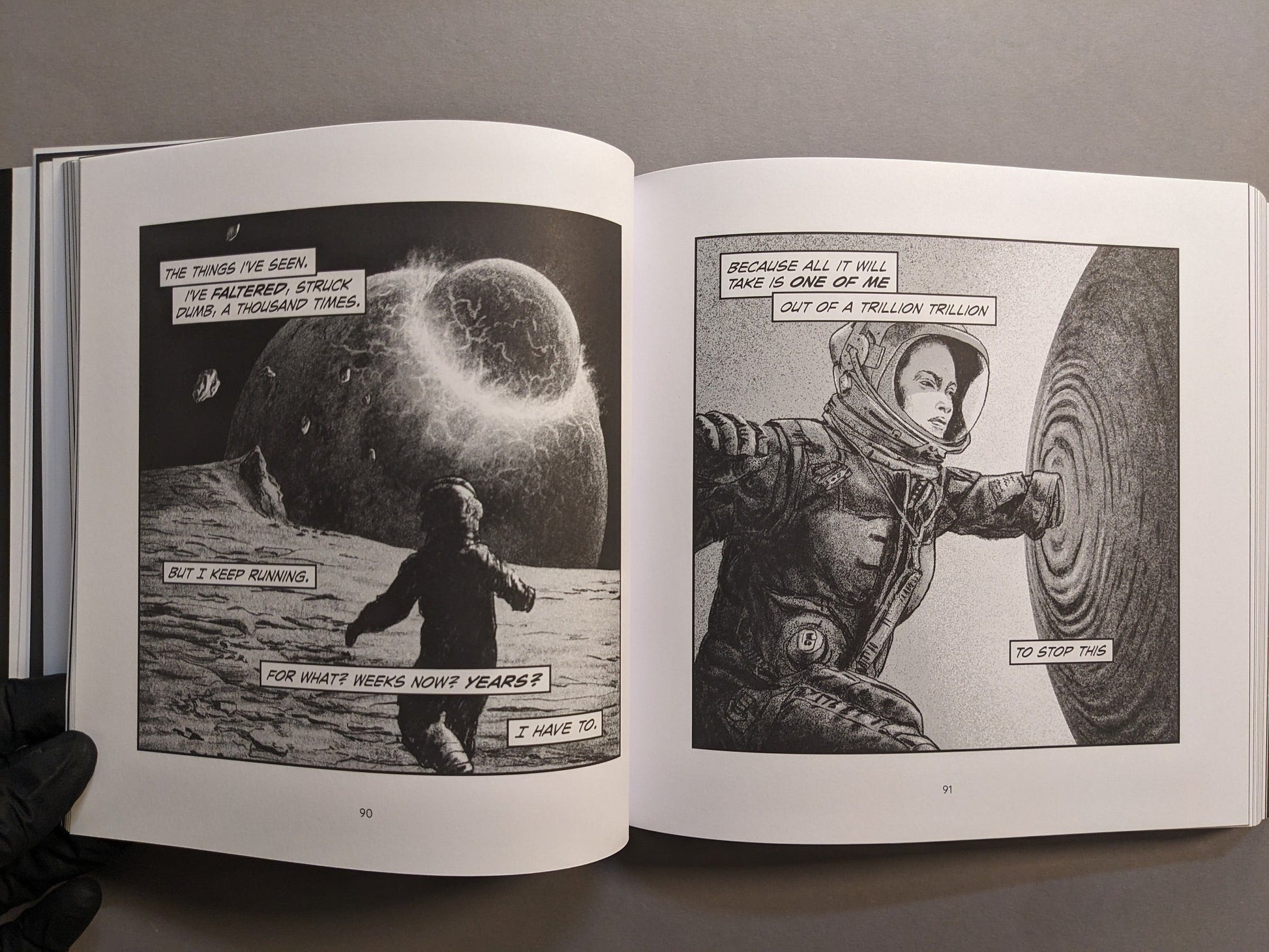 Interior spread: astronaut under looming moon and touching a rippling surface; stark, high-contrast black-and-white.