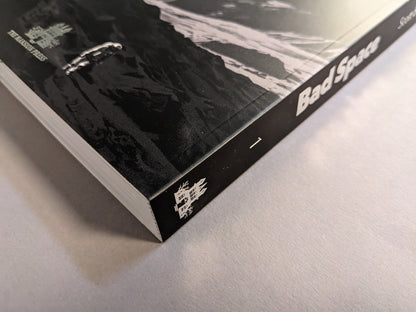 Spine close-up of Bad Space – Volume 1 by Scott Base showing the title and The Mansion Press mark; softcover with flaps, hot silver stamping.