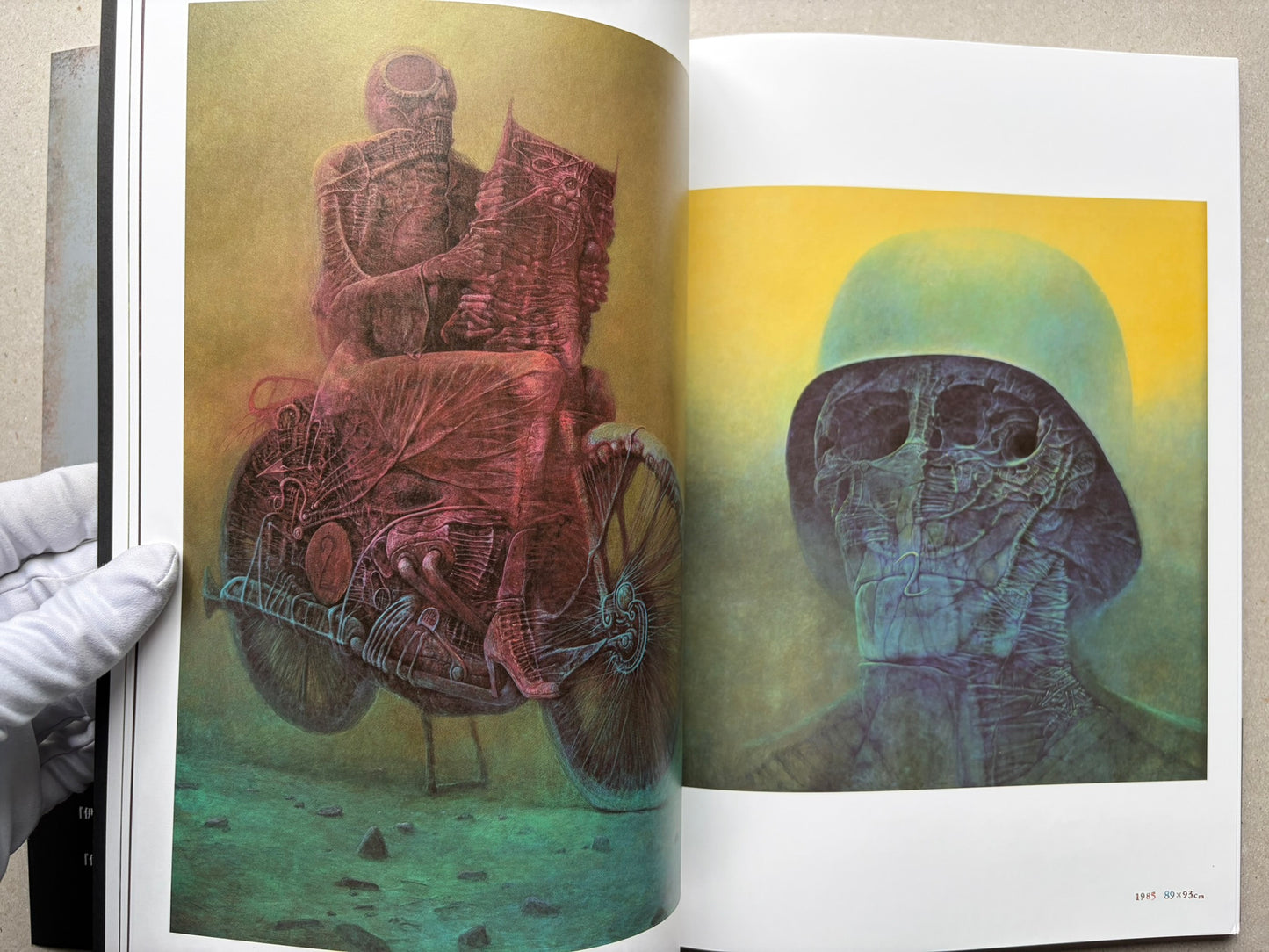 Open spread from Beksinski - The Collected Works I ver. 1.2 with two paintings of seated or masked figures in pink and green tones.
