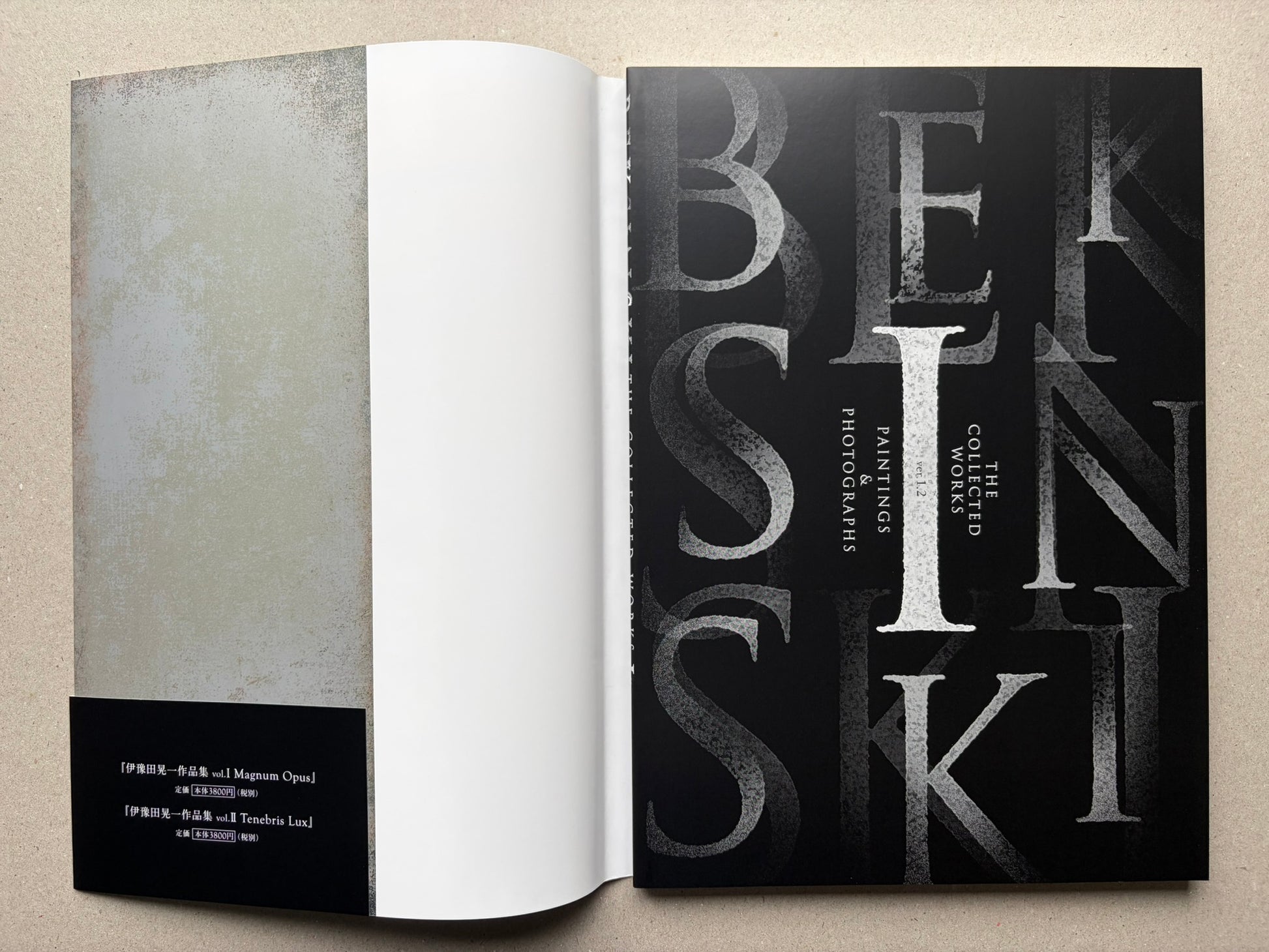 Open Beksinski book showing a title spread, with a blank left page and a black title page on the right.