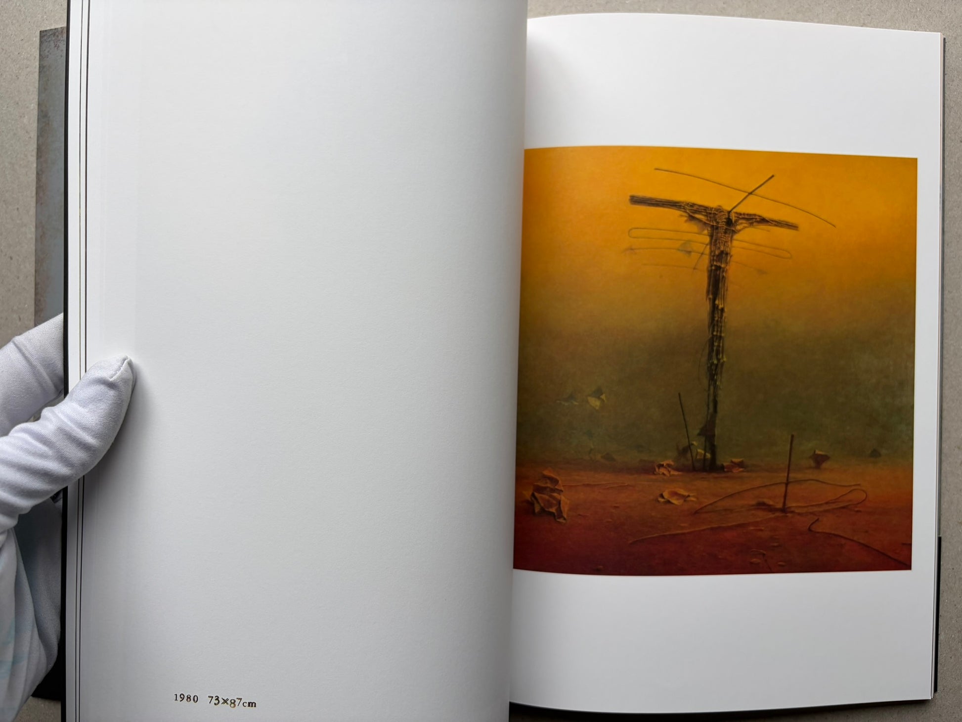 Open spread from Beksinski - The Collected Works I ver. 1.2 with a single orange painting of a tall, narrow form.