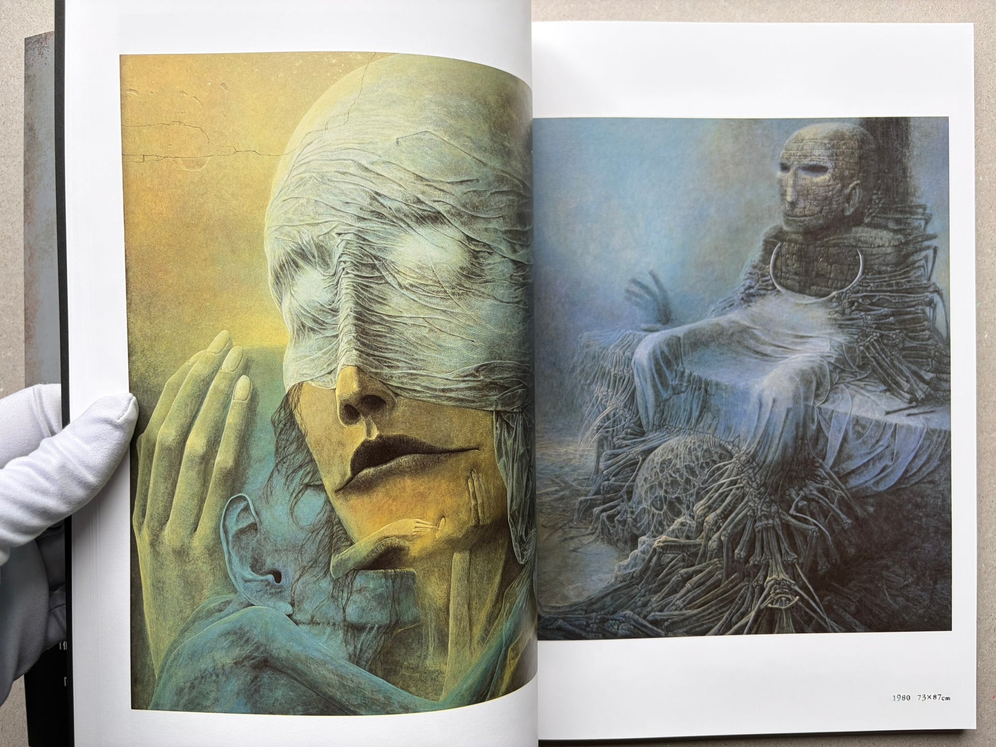 Open spread from Beksinski - The Collected Works I ver. 1.2 with two colour paintings of masked or veiled figures.