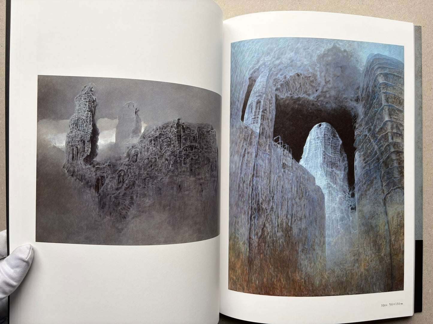 Beksiński: The Collected Works II ver. 1.2 open to two relief images on a black page.