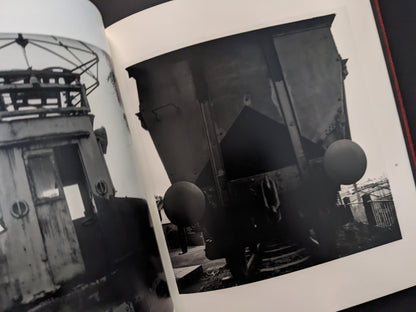 Black and white photograph of an abandoned industrial train cabin and mining equipment from Berg Werk by Sincei Yamamoto