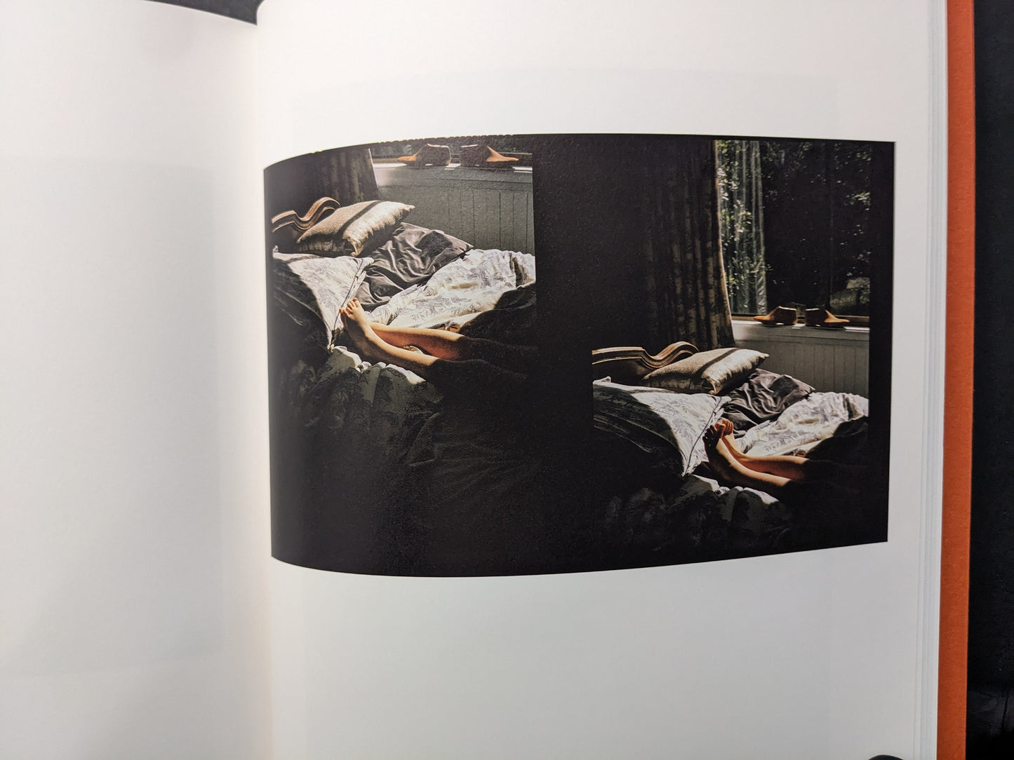 Interior photograph from “between the skin and sea” by Katrin Koenning: double image of a bed in low light, colour.