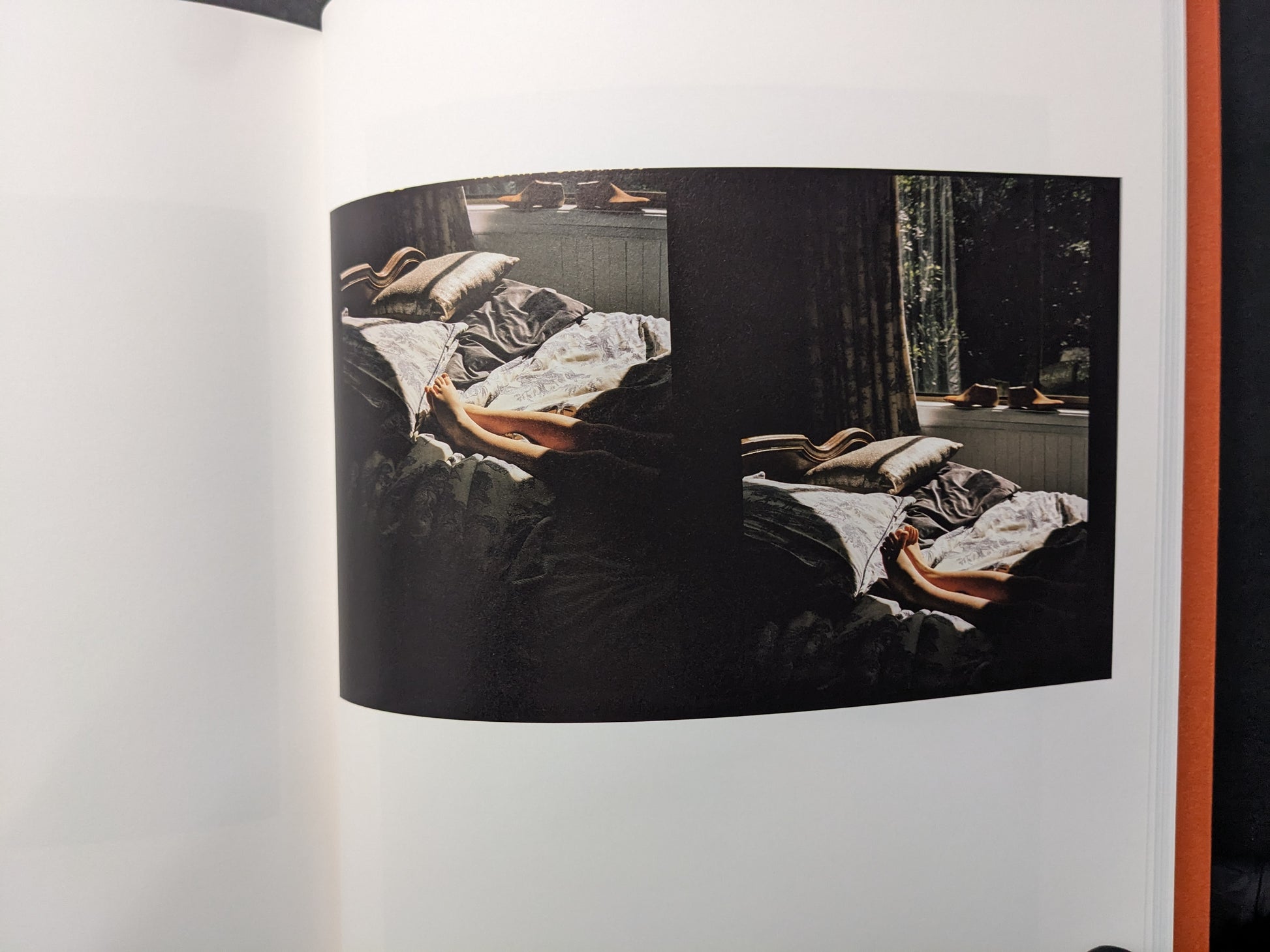 Interior photograph from “between the skin and sea” by Katrin Koenning: double image of a bed in low light, colour.