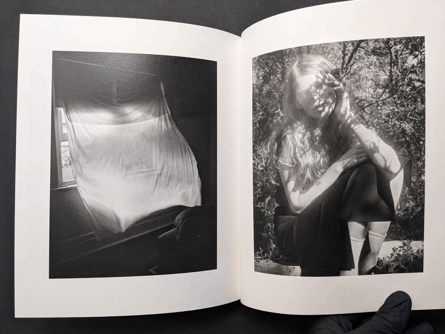 Interior spread from “between the skin and sea” by Katrin Koenning: draped fabric at a window and a portrait outdoors, black-and-white.