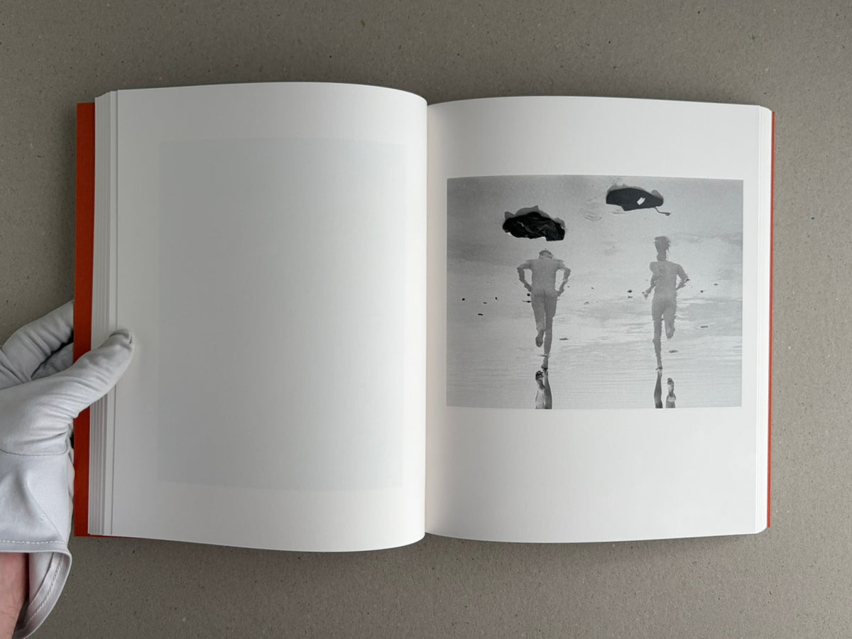 Open photobook spread from between the skin and sea – Katrin Koenning, showing a monochrome image on the right page and a blank page on the left.