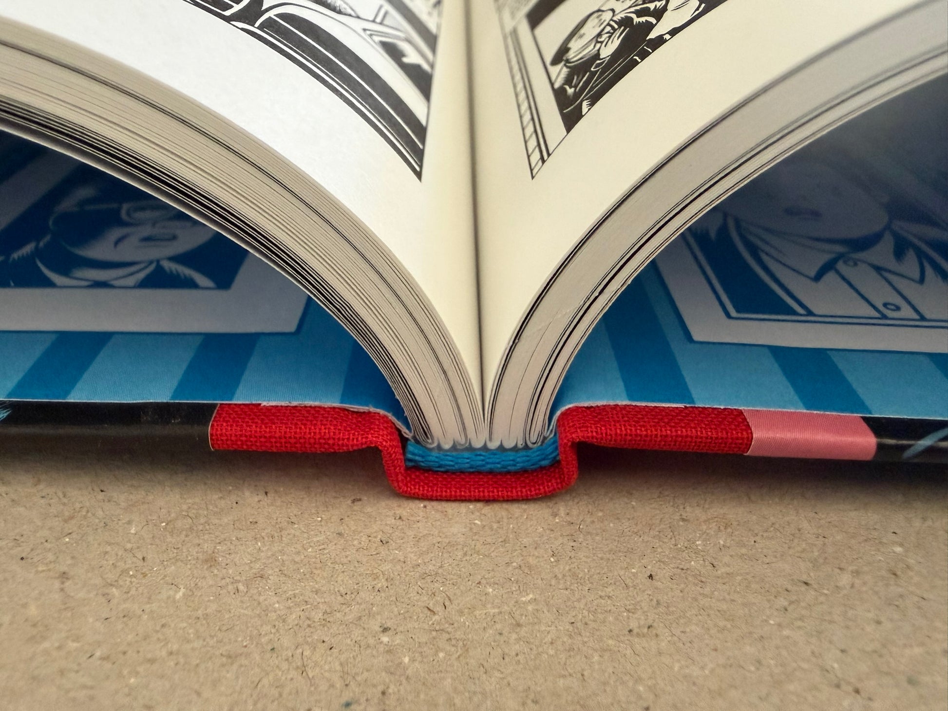 Open book showing a black-and-white interior spread from Big Baby with French comic panels.