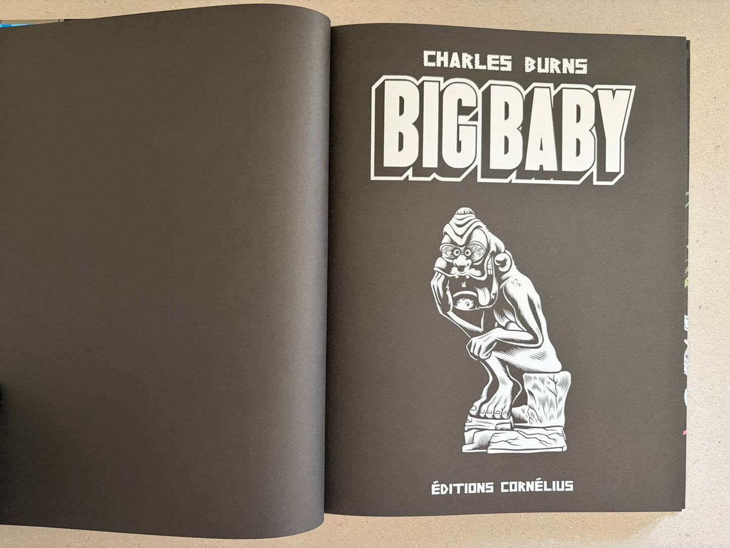 Title page spread for Big Baby by Charles Burns on black paper, with a white monster illustration.