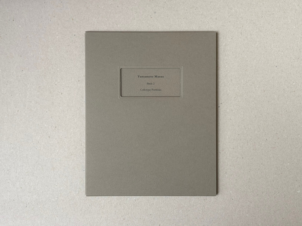 Birds 2 by Masao Yamamoto, grey portfolio case with title label on the front.