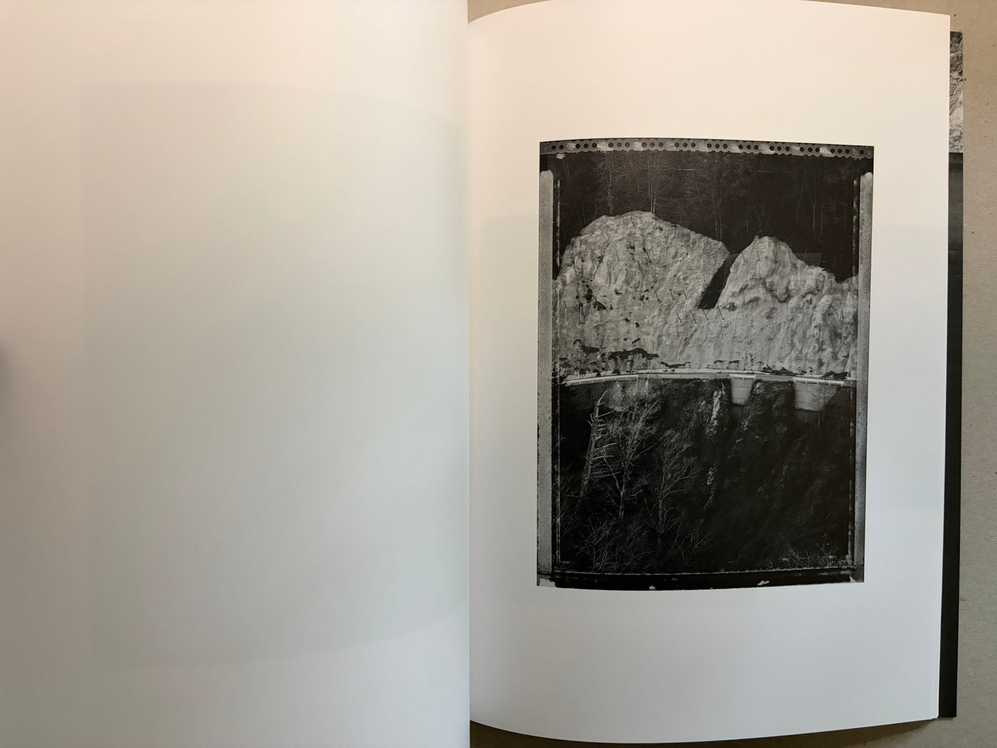 Boundary Hunt by Toshio Shibata, open spread with a black-and-white photograph of a dam or retaining wall above a dark drop.