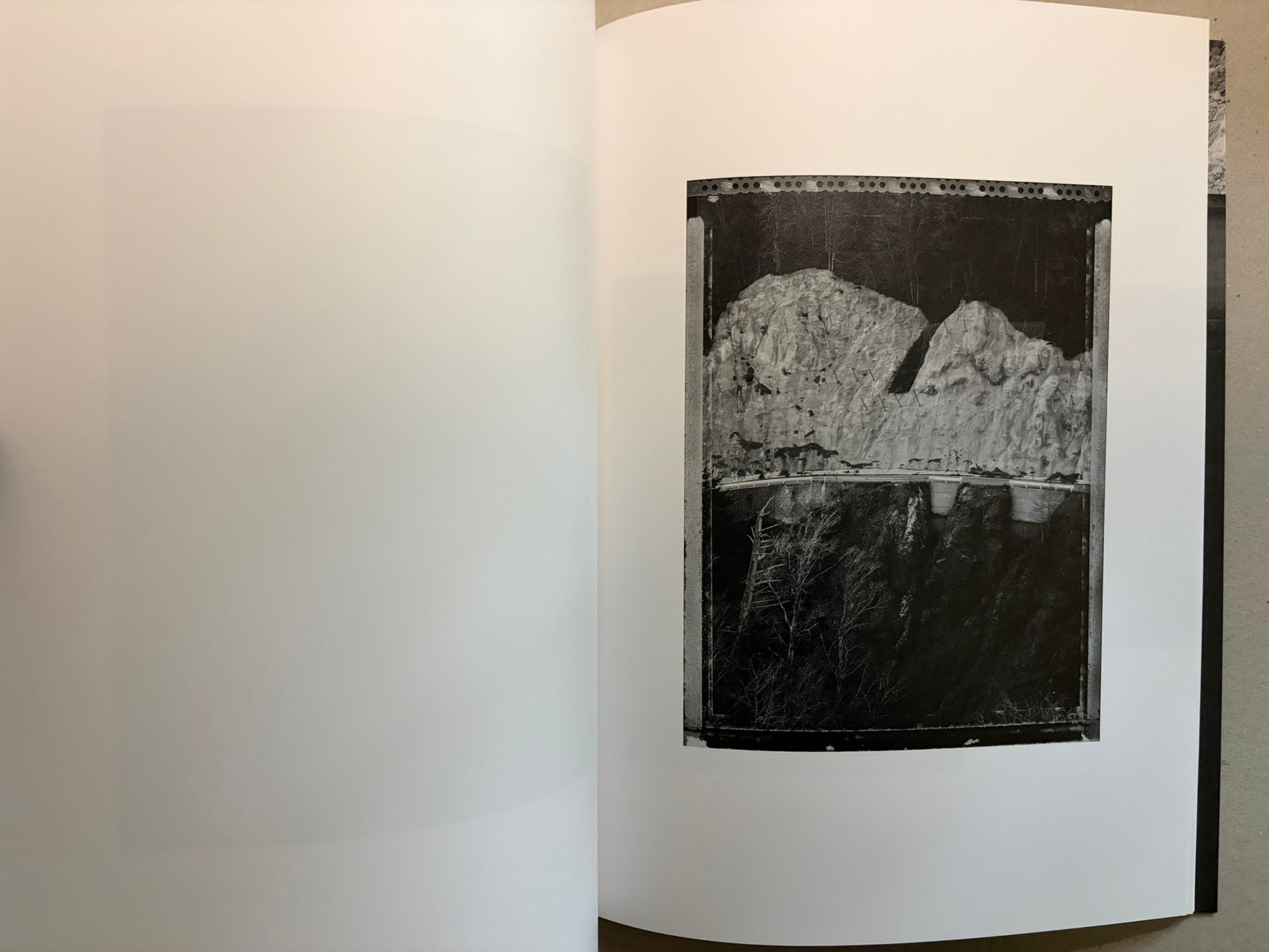 Boundary Hunt by Toshio Shibata, open spread with a black-and-white photograph of a dam or retaining wall above a dark drop.