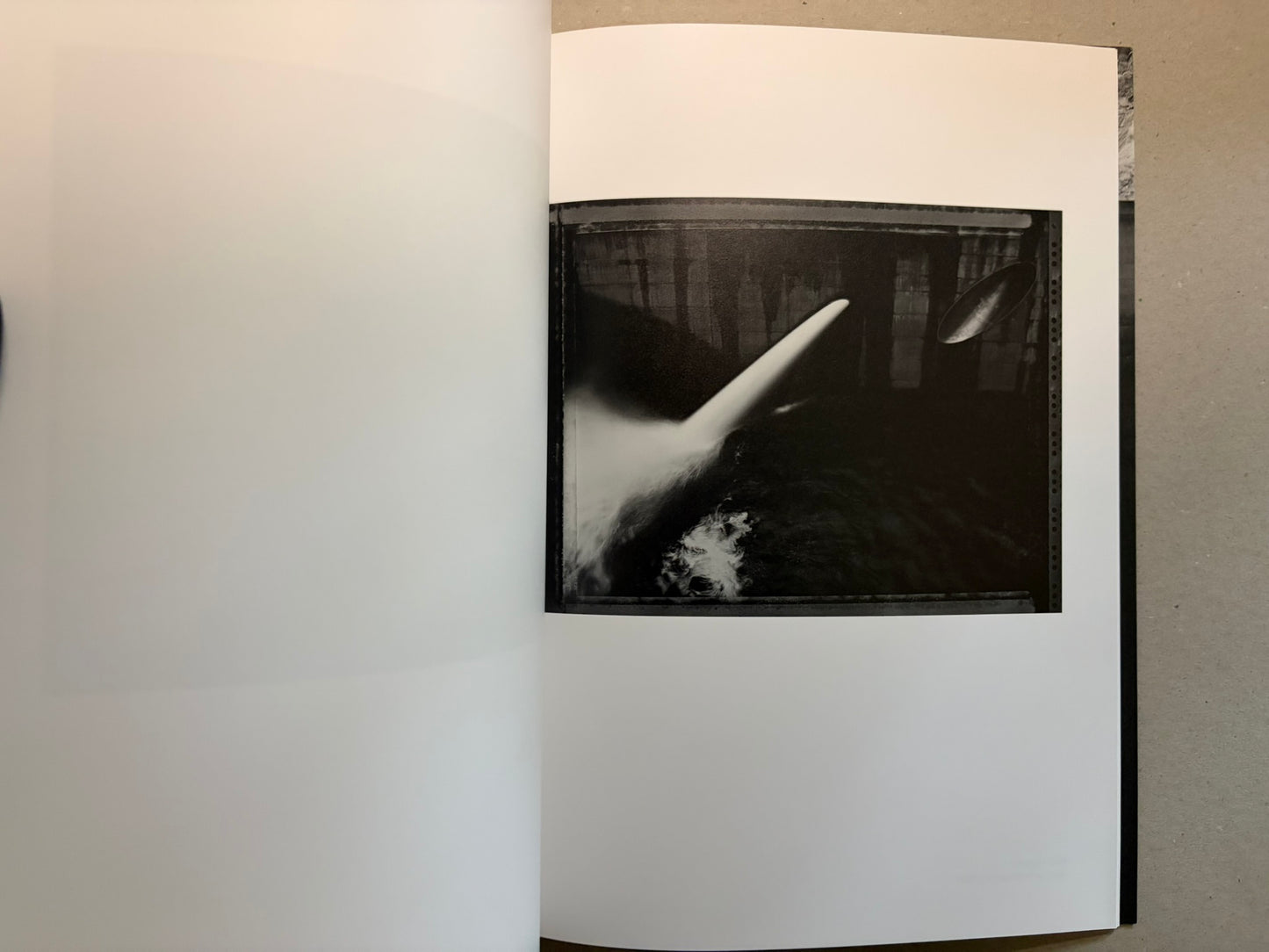 Boundary Hunt by Toshio Shibata, open spread with a black-and-white photograph of a slanted water jet or spillway.