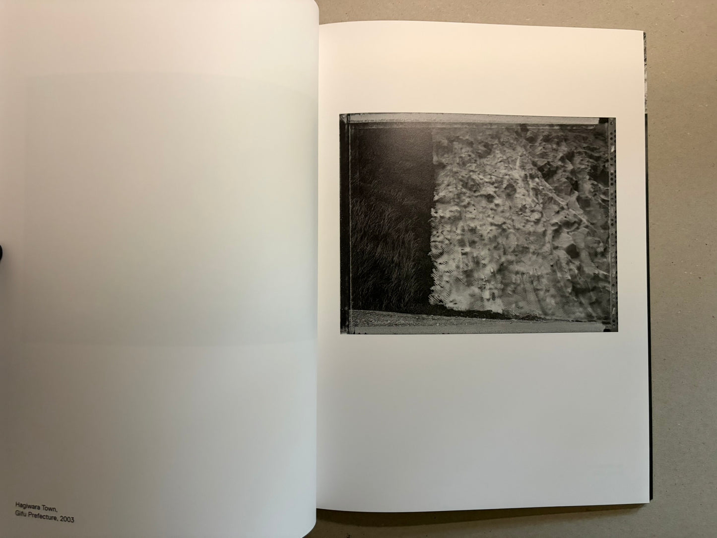 Boundary Hunt by Toshio Shibata, open spread with a black-and-white photograph of a textured wall or embankment on the right page.