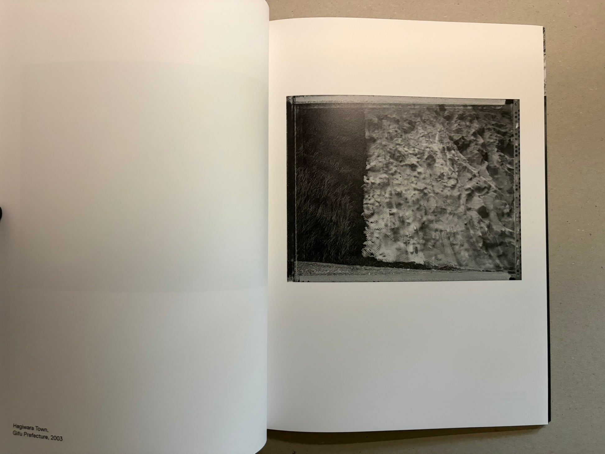 Boundary Hunt by Toshio Shibata, open spread with a black-and-white photograph of a textured wall or embankment on the right page.
