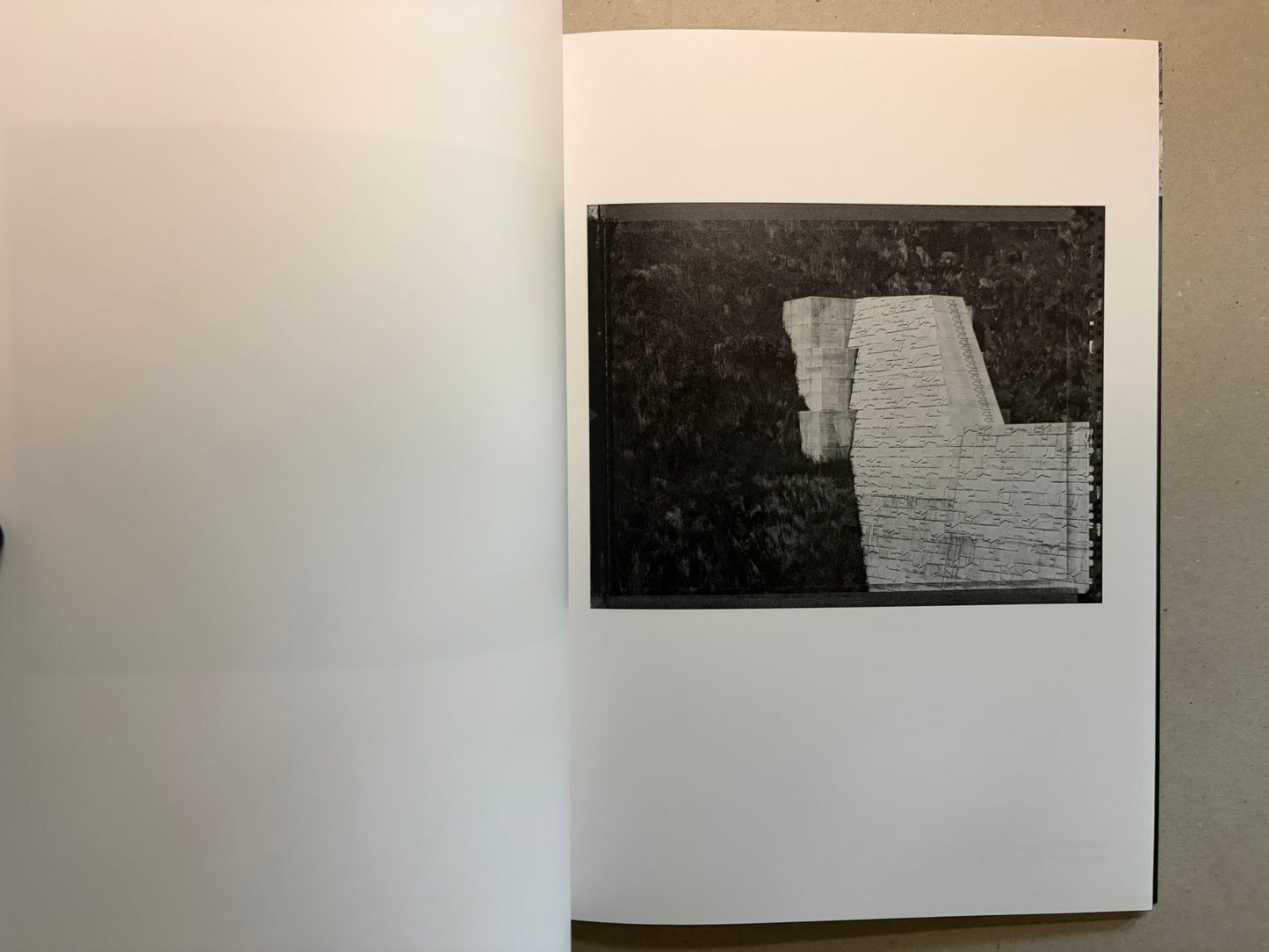 Boundary Hunt by Toshio Shibata, open spread with a black-and-white photograph of a stepped retaining structure and water on the right page.