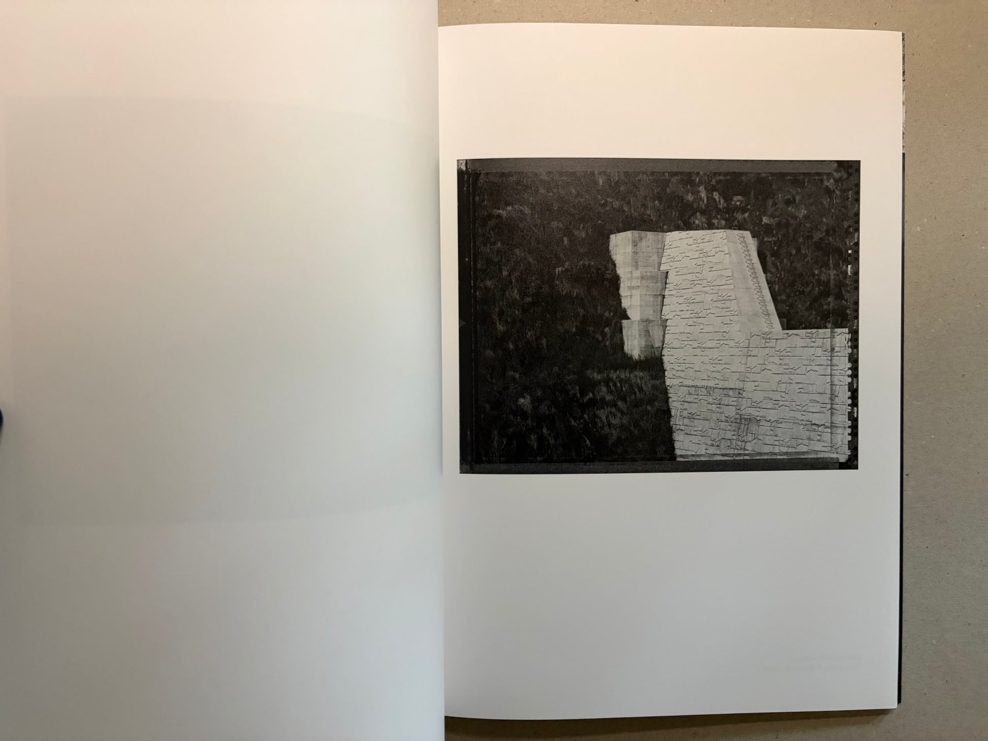 Boundary Hunt by Toshio Shibata, open spread with a black-and-white photograph of a stepped retaining structure and water on the right page.