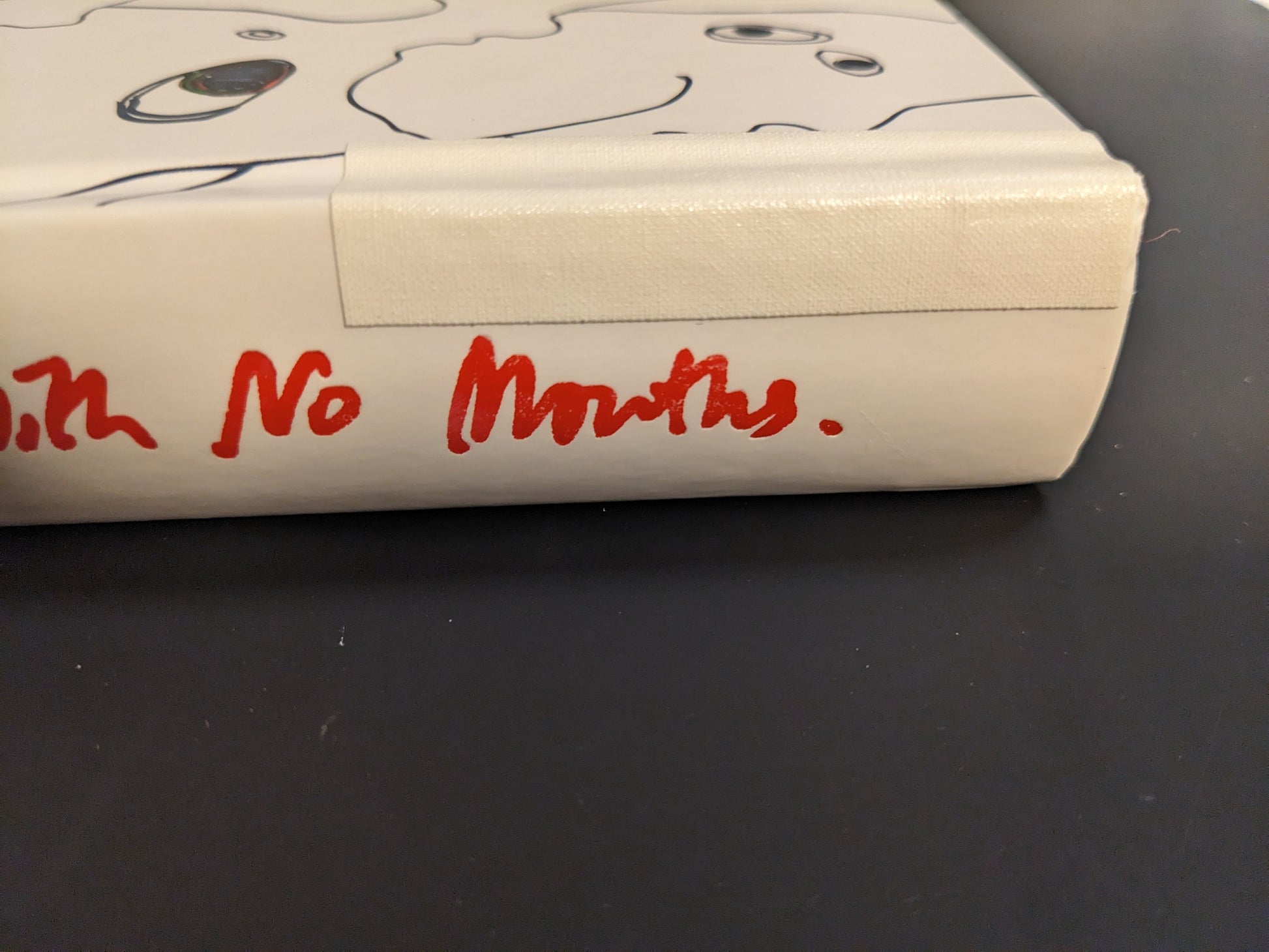 Detail of the book spine repaired with white cloth tape.