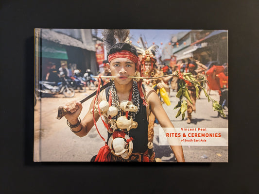 Front cover of the book "Rites & Ceremonies of South East Asia" by Vincent Peal with a portrait of a young participant in a ritual procession.