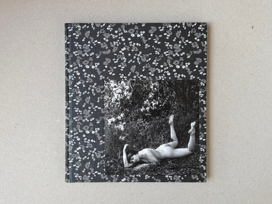 Cover of Cheryomushki by Nikolay Bakharev, showing a black-and-white photograph of a nude figure lying in grass, framed by a floral patterned border.