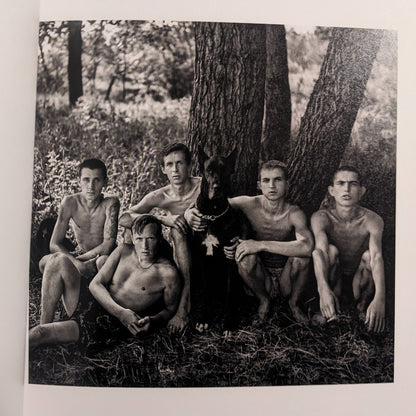 Interior photo from Cheryomushki: group portrait of young men gathered under a tree with a dog.