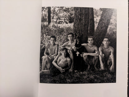 Interior photo from Cheryomushki: group portrait of young men gathered under a tree with a dog.