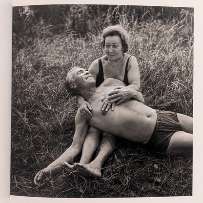 Interior photo from Cheryomushki: black-and-white portrait of an older couple resting in grass, posed affectionately.