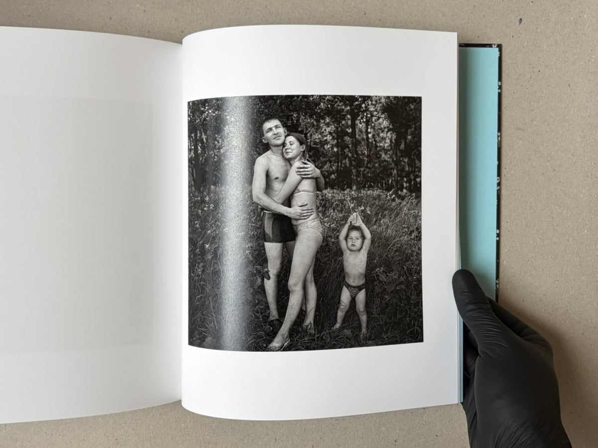 Open book spread from Cheryomushki — Nikolay Bakharev, showing a black-and-white photograph of a couple embracing with a child standing beside them.