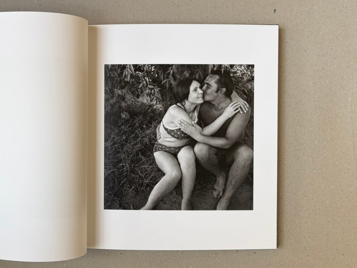 Open page in Cheryomushki — Nikolay Bakharev showing a black-and-white photograph of a seated couple embracing outdoors.