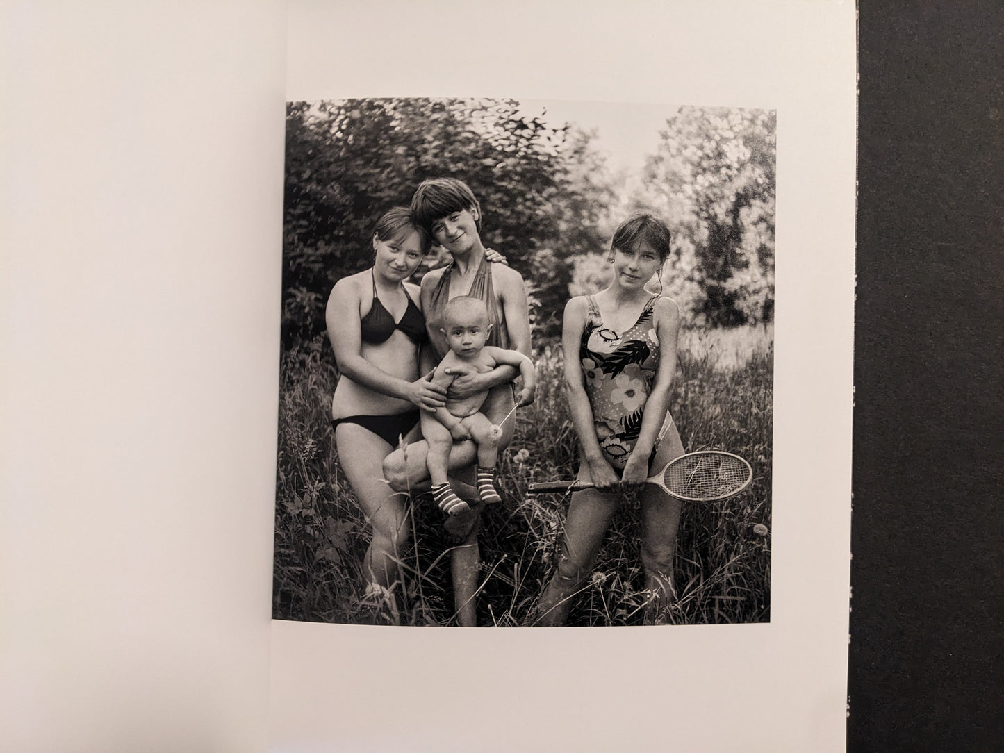 Cheryomushki by Nikolay Bakharev interior photo: black-and-white portrait of three girls with a toddler outdoors, one holding a badminton racket.