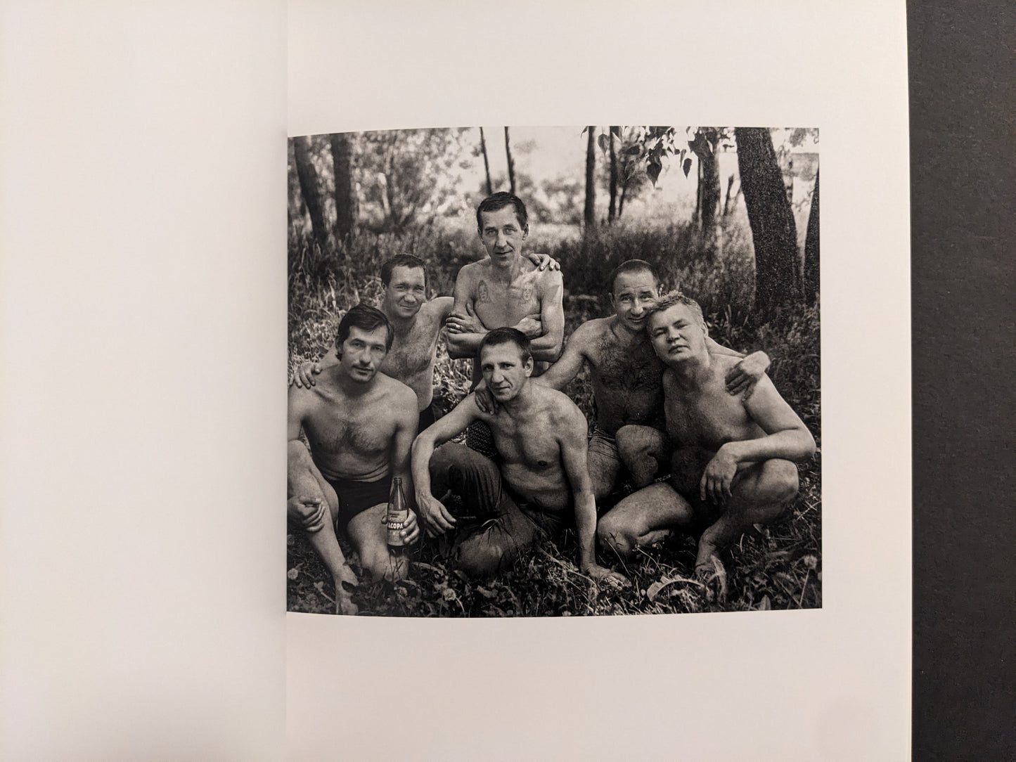 Cheryomushki by Nikolay Bakharev interior photo: black-and-white group portrait of six men resting in the woods, one holding a bottle.