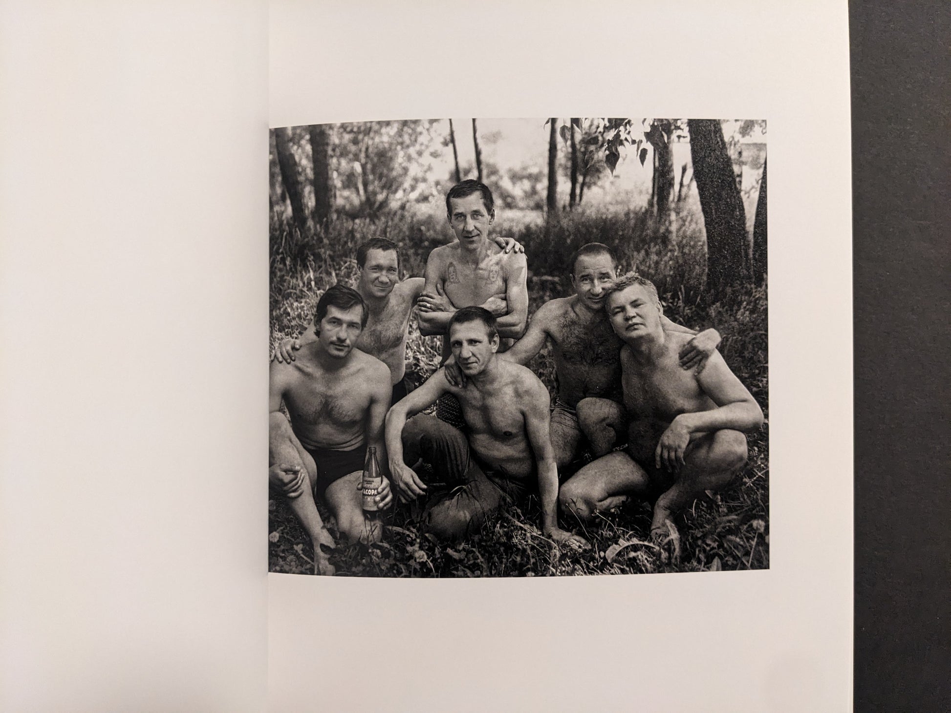 Cheryomushki by Nikolay Bakharev interior photo: black-and-white group portrait of six men resting in the woods, one holding a bottle.