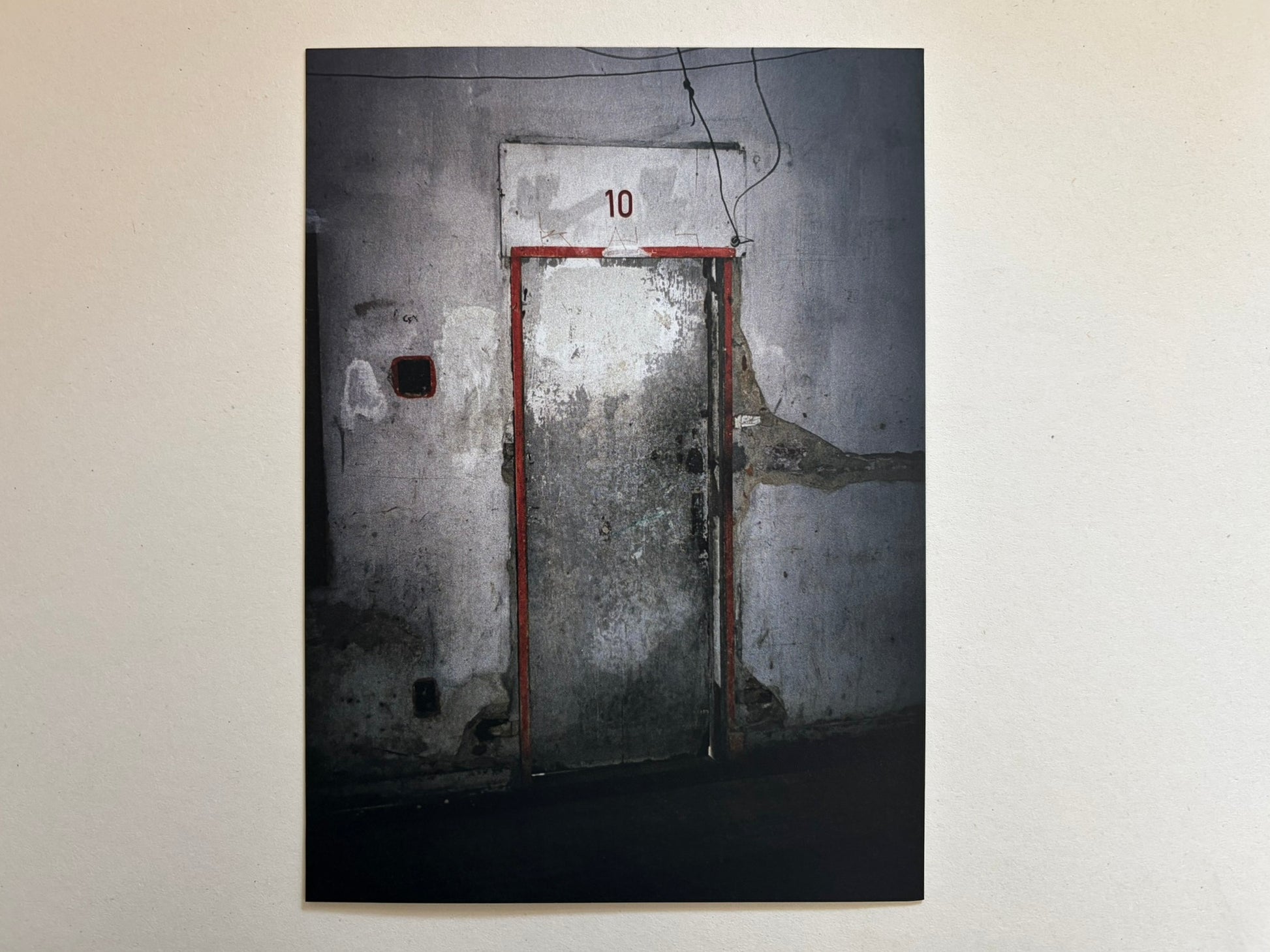A colour print from Cidade de Pedra showing a worn door marked with the number 10.